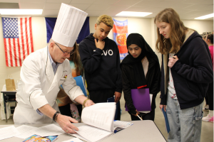  Students looking at a book with a chef